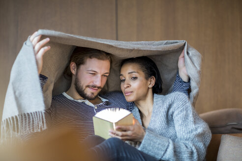 Porträt eines jungen Paares, das sich auf der Couch entspannt - FMKF04679