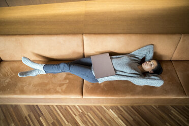 Woman with laptop relaxing on couch - FMKF04739