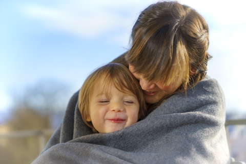 Porträt eines glücklichen kleinen Jungen in der Nähe seiner Mutter, lizenzfreies Stockfoto