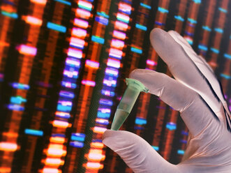 Wissenschaftler mit einer DNA-Probe, deren Ergebnisse auf einem Computer in einem Labor angezeigt werden - ABRF00027