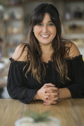 Portrait of smiling woman in a cafe - SBOF01185