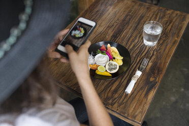 Frau fotografiert Essen auf einem Teller mit Smartphone - SBOF01194