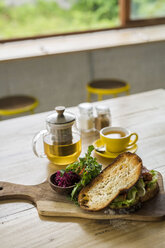 Krustenbrot mit grünem Salat und Roter Bete auf Holzteller und grünem Tee im Café - SBOF01219