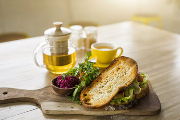 Krustenbrot mit grünem Salat und Roter Bete auf Holzteller und grünem Tee im Café - SBOF01220