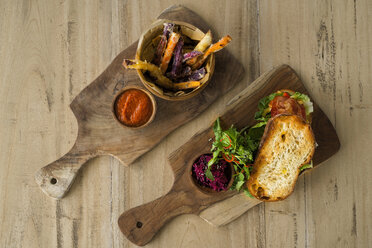 Zwei Holzteller mit hausgemachten Süßkartoffel- und Kartoffelpommes, Tomatendip und knusprigem Brot mit Salat, Schinken und Roter Bete - SBOF01236