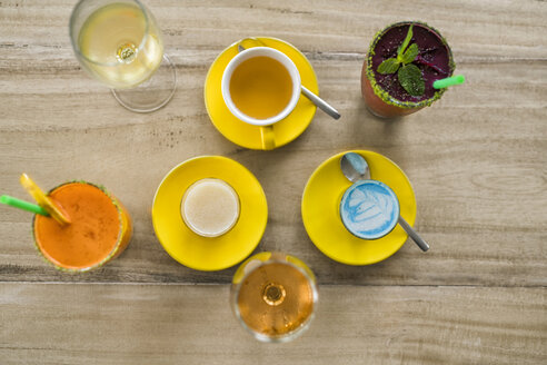 Holztisch mit verschiedenen Getränken wie Smurf Latte, Smoothie, Wein und Tee - SBOF01239