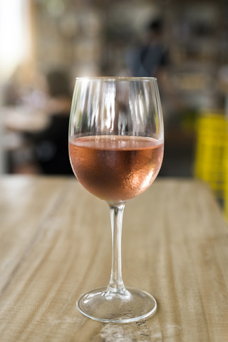 Glass of rose wine on wooden tale stock photo