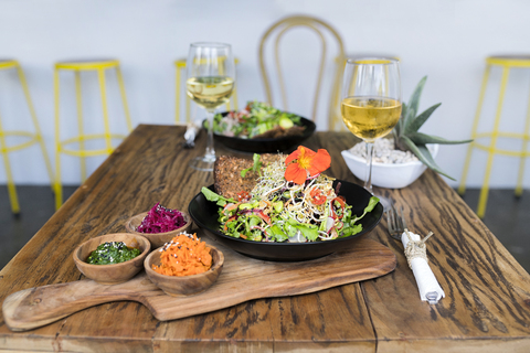 Decorated salad bowls on wooden table with glasses of wine stock photo