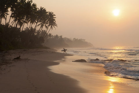 Sri Lanka, Mirissa, Sonnenaufgang, Strand mit Surfer, lizenzfreies Stockfoto