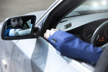 Junger Mann am Steuer seines Autos, Blick in den Außenspiegel - MAEF12501