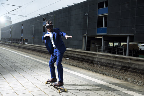 Junger Mann mit Longboarding am Bahnhof, mit VR-Brille - MAEF12506