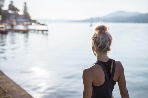 Rückansicht einer Frau in Sportkleidung an einem See - DAWF00582