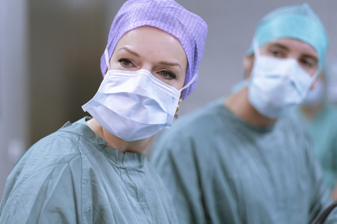 Neurochirurgen in Kitteln während einer Operation, lizenzfreies Stockfoto