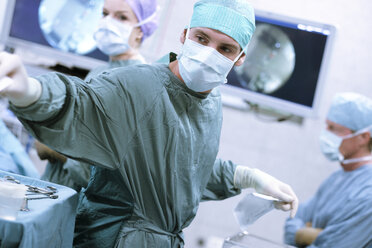 Chirurgische Krankenschwester bei der Arbeit während einer Operation - MWEF00191