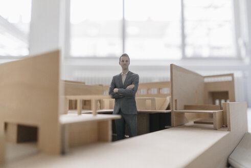 Miniature businessman figurine standing in architectural model - FLAF00117