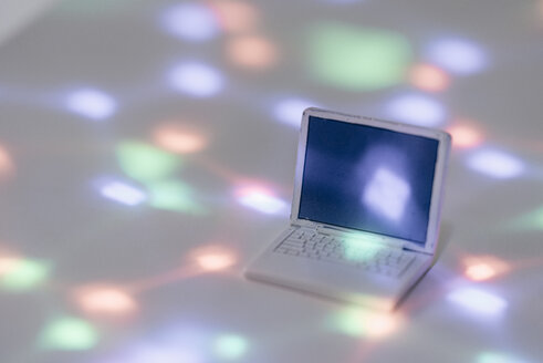 Miniatur-Laptop-Modell, umgeben von Lichtpunkten - FLAF00136