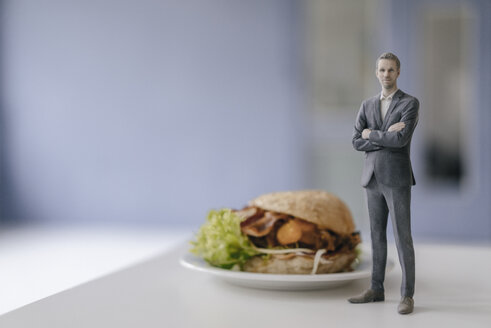 Miniature businessman figurine standing next to fast food - FLAF00138