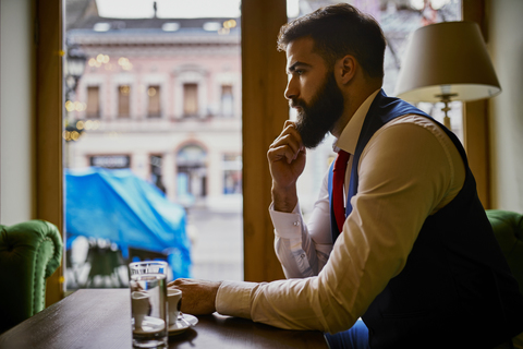 Pensive fashionable young man sitting in a cafe stock photo