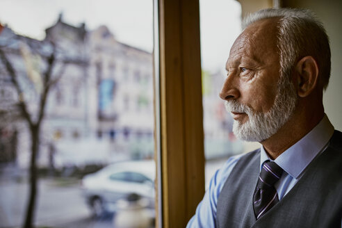 Eleganter älterer Mann schaut aus dem Fenster - ZEDF01114