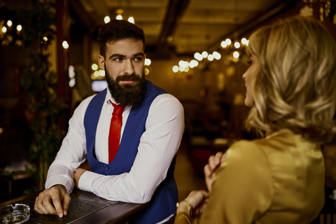 Fashionable young man looking at woman in a bar stock photo