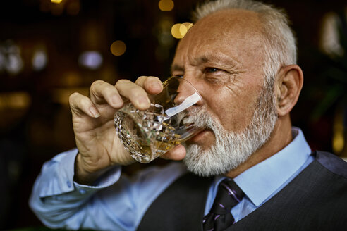 Porträt eines eleganten älteren Mannes, der aus einem Becher trinkt - ZEDF01122