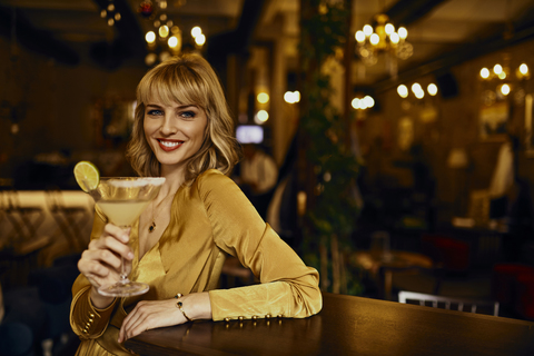 Porträt einer eleganten Frau mit Cocktail in einer Bar, lizenzfreies Stockfoto