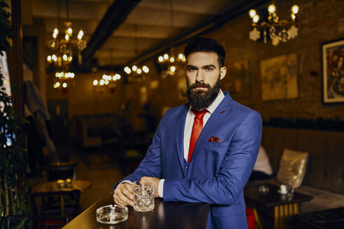 Porträt eines eleganten jungen Mannes in einer Bar mit Becher - ZEDF01140