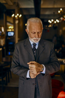 Eleganter älterer Mann, der seine Manschetten anpasst - ZEDF01166