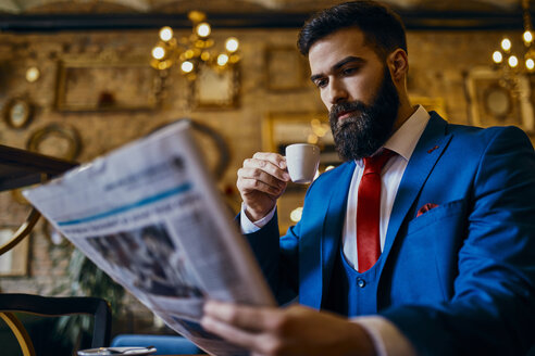 Eleganter Mann trinkt Kaffee und liest Zeitung in einem Cafe - ZEDF01176