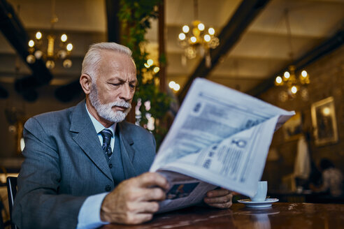 Eleganter älterer Mann liest Zeitung in einem Café - ZEDF01180