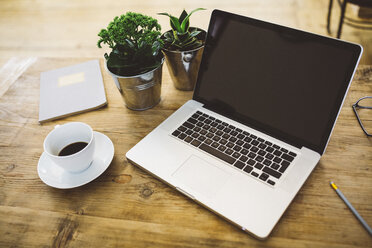 Laptop und eine Tasse Kaffee auf einem Tisch - GIOF03788