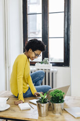 Young woman at home surfing the net, using laptop - GIOF03794