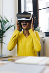 Laughing young woman playing game, wearing virtual reality goggles - GIOF03813