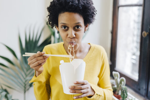 Young woman eating Asian noodles for lunch with chopsticks - GIOF03820