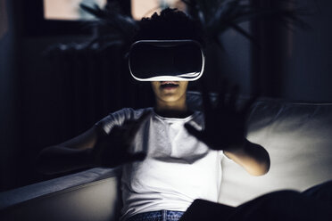 Junge Frau benutzt VR-Brille zu Hause - GIOF03851