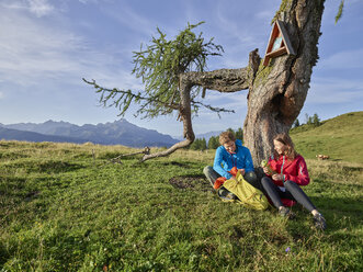 Austria, Tyrol, Mieming Plateau, hikers having a break on alpine meadow - CVF00054