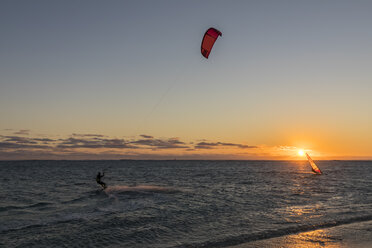 Mauritius, Le Morne, Indian Ocean, kite surfer and sail boarder at sunset - FOF09770