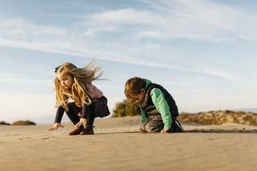 Zwei Kinder spielen mit dem Sand am Strand im Winter - JRFF01528
