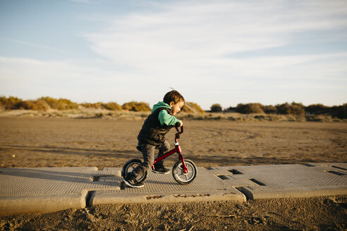 Junge läuft mit einem Fahrrad am Strand im Winter - JRFF01531