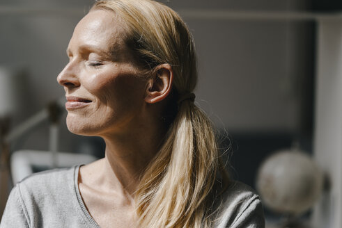 Portrait of smiling woman's face in sunlight - KNSF03563