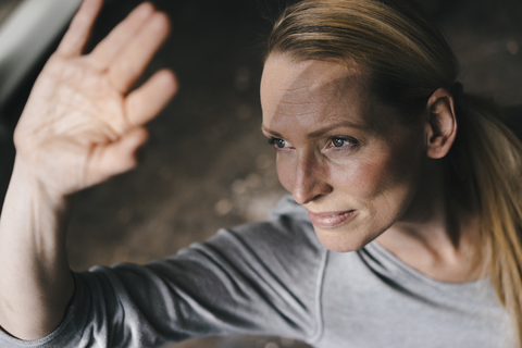 Frau, die ihre Augen mit der Hand abschirmt, lizenzfreies Stockfoto