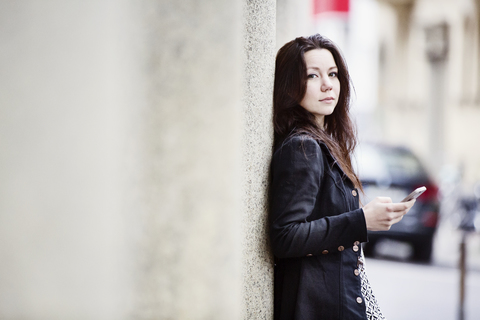 Porträt einer modischen jungen Frau mit Mobiltelefon, lizenzfreies Stockfoto