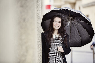 Porträt einer modischen jungen Frau mit schwarzem Vintage-Regenschirm - JATF00993
