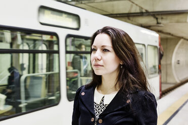 Germany, Cologne, portrait of young woman waiting at underground station platform - JATF00999