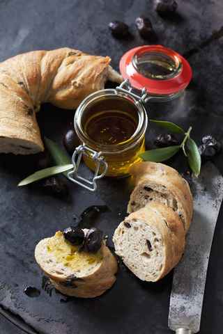 Ringbrot mit schwarzen Oliven, Glas Olivenöl und schwarze Oliven, lizenzfreies Stockfoto