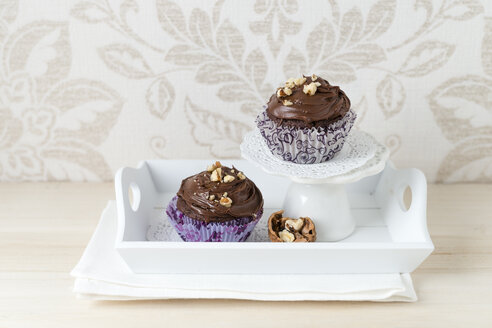 Zwei Tassenkuchen mit Schokoladencreme und geknackten Walnüssen im Pappbecher - MYF01990