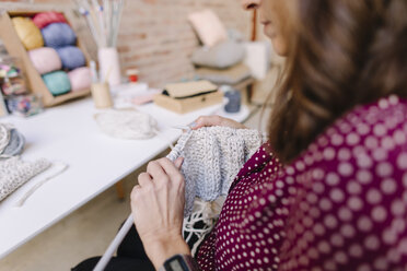 Close-up of woman knitting at table - OCAF00021