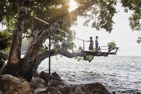 Thailand, Railay, Rai Leh East Beach, boy and little girl on tree house above the sea stock photo