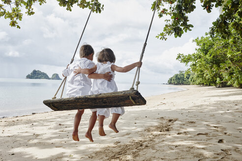Thailand, Ko Yao Noi, Junge und kleines Mädchen auf einer Schaukel am Strand - RORF01088