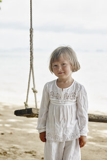Thailand, Ko Yao Noi, Porträt eines kleinen Mädchens auf einer Schaukel am Strand - RORF01089